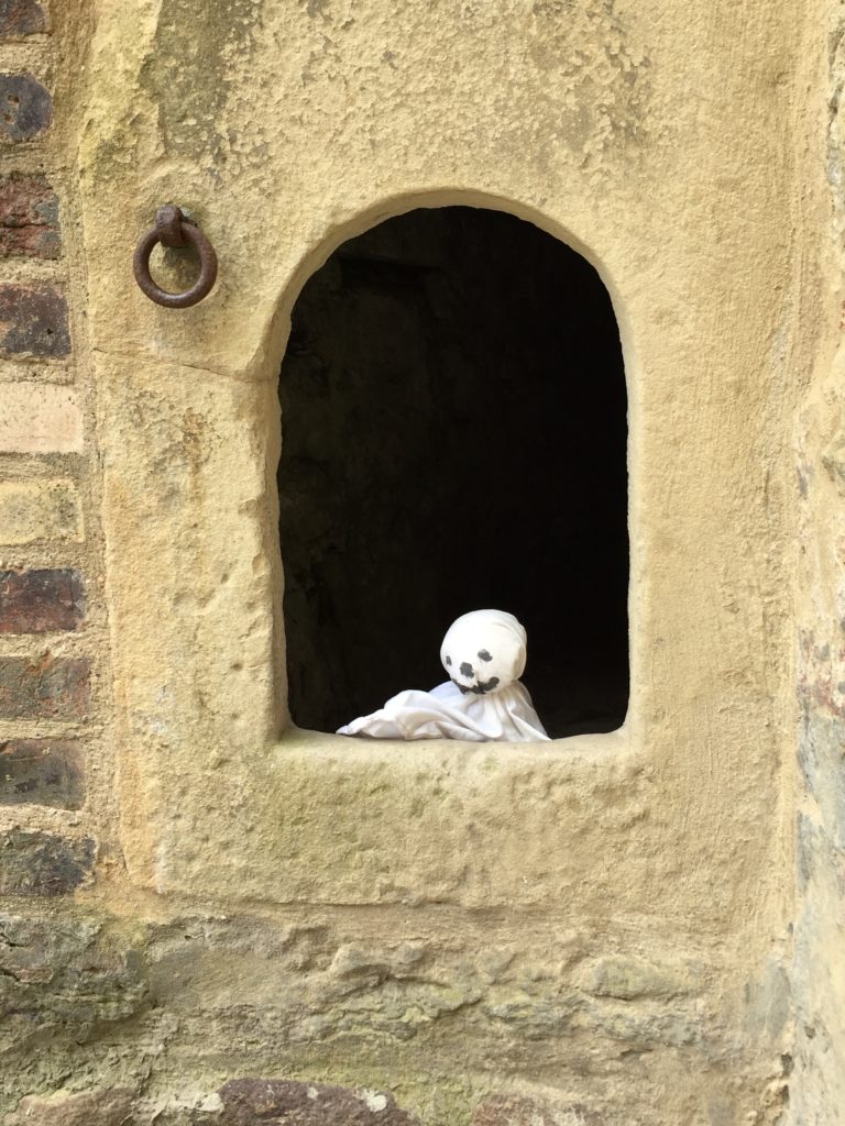 Foto Kinderfühurng Huberta das kleine Burggespenst. Foto kleines Gespenst aus Stoff in einem Loch in der Burgmauer