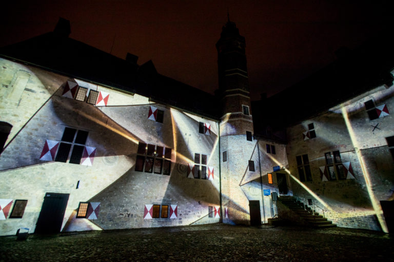 Bild zur Jubiläumsveranstaltung geometrische Illuminationen an der Fassade der Burg Vischering