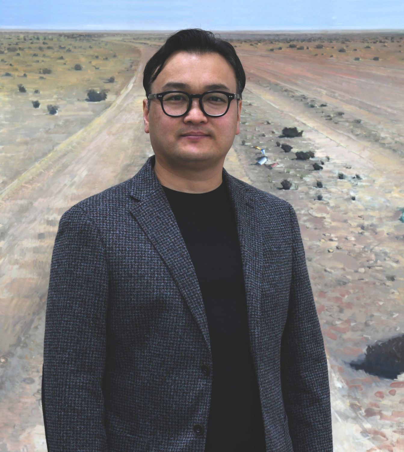 Portrait des Künstlers Gan-Erdene Tsend vor seinem Bild "Heimweg"