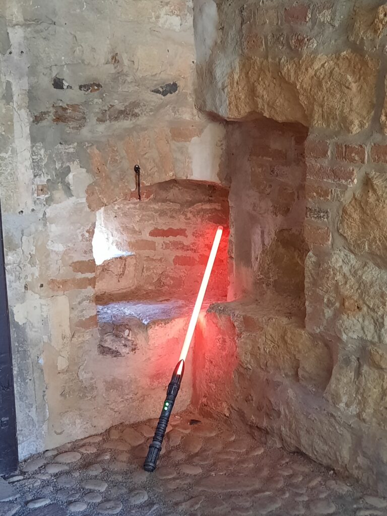 Ein rotes Lichtschwer lehnt an der Burgmauer der Burg Vischering