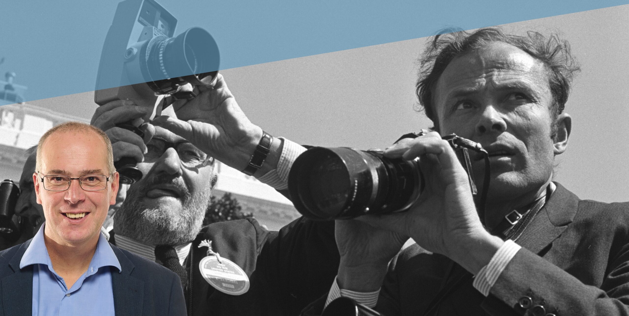 Historiker Prof. Dr. Markus Köster vor einer Fotografie Engelbert Reineckes, die zwei Fotografen bei der Arbeit zeigt.