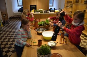 Kinder beim Programm Gänseblümchen und Löwenzahn beim zubereiten eines Kräuterquarks.